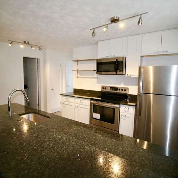 a kitchen with a granite counter top and stainless steel appliances.