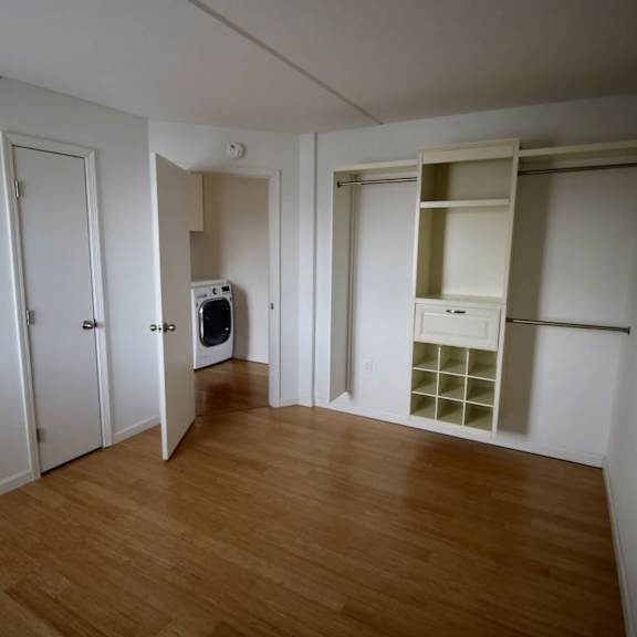 a room with a wood floor and white walls.