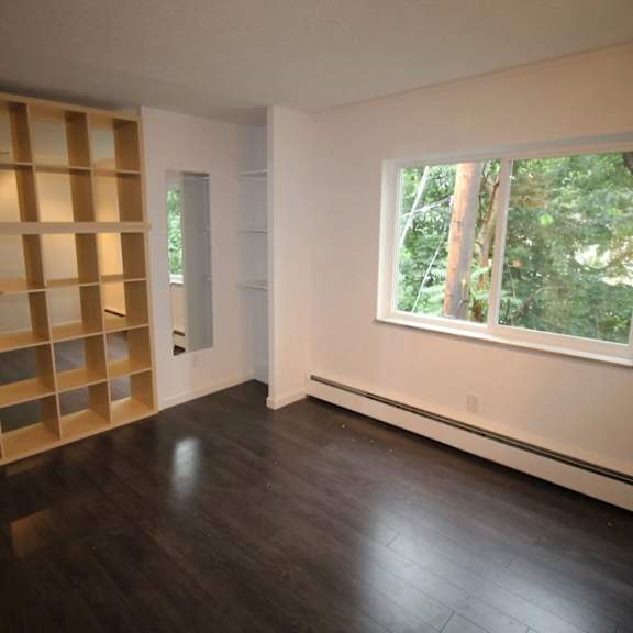 a room with a window and a shelving unit.