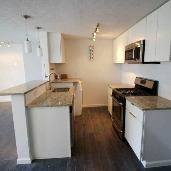 a kitchen with granite countertops and white cabinets.