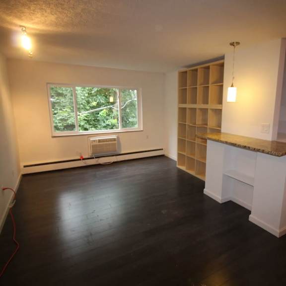 a room with a window and a wooden cabinet.