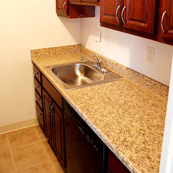 a kitchen with a granite counter top and wooden cabinets integrity realty, cleveland, oh