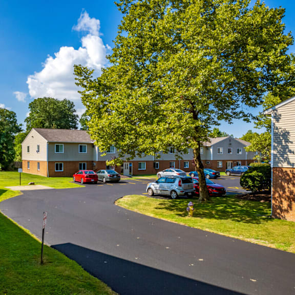 the view of a neighborhood with houses and cars parked on the street