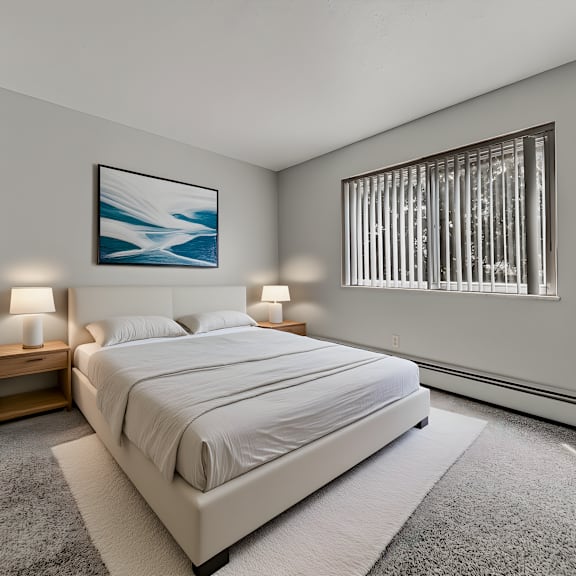 a bedroom with a large bed, a potted plant, and a painting on the wall. at integrity berea apartments, ohio