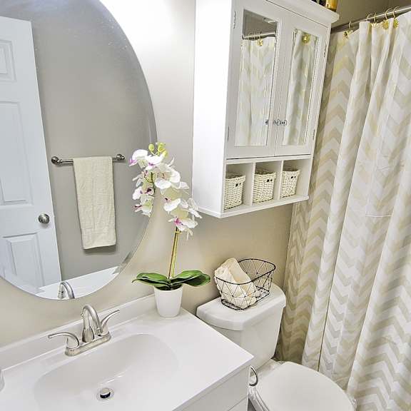 upgraded apartment bathroom with white cabinets.