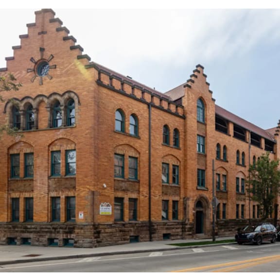 a red brick building with a clock on the top left side.