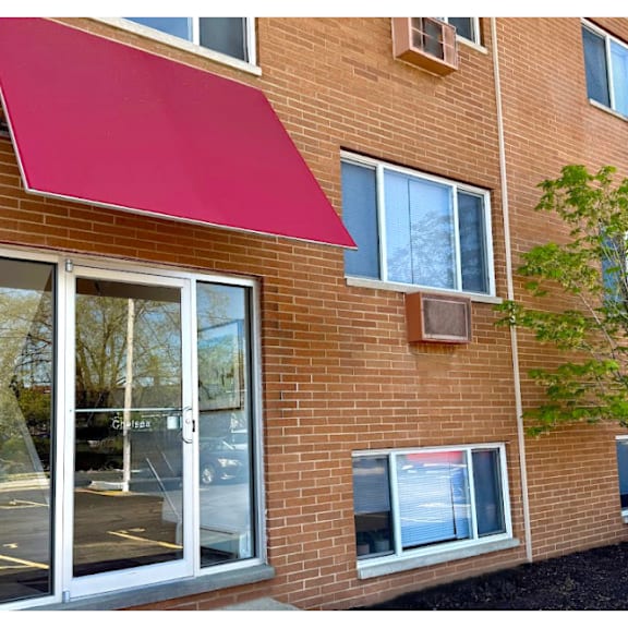 a red awning is attached to a brick building.