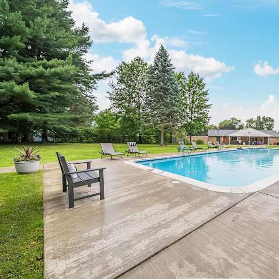 a large outdoor swimming pool surrounded by trees and a wooden deck.