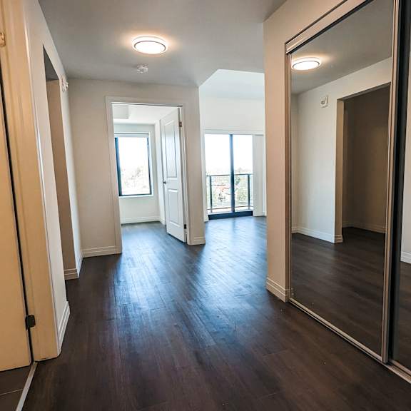a hallway with a mirror on the wall and a door on the right.