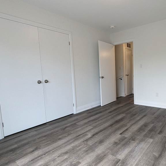 a room with a white door and a wooden floor.