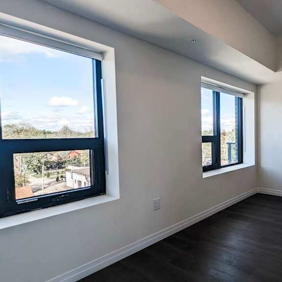 a room with a door, a window, and a television.