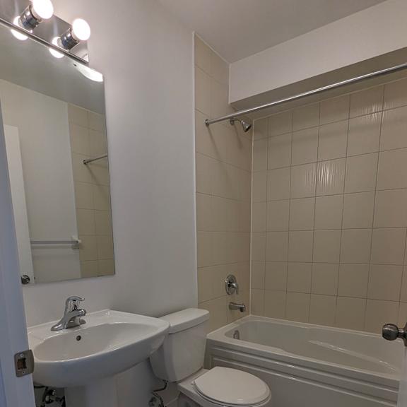 a white bathroom with a sink, toilet and bathtub.