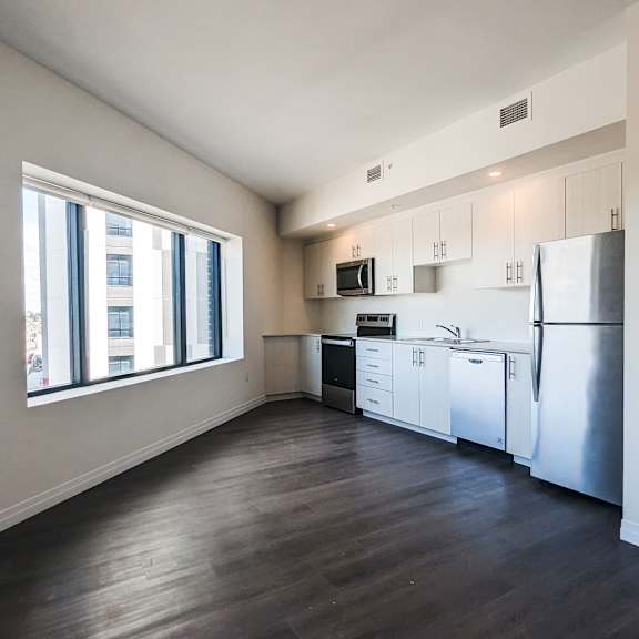 a kitchen with a refrigerator, sink, and cabinets.