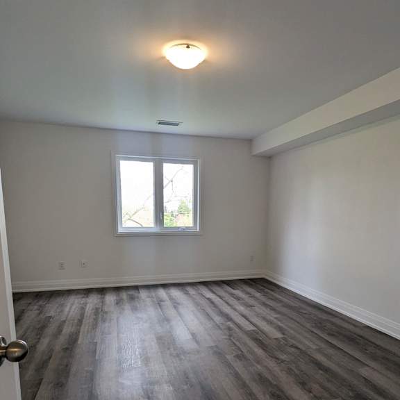 a room with a wooden floor and a window.