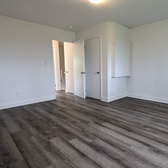 a room with wooden flooring and white walls.