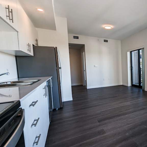 a kitchen with white cabinets and a black fridge is shown.