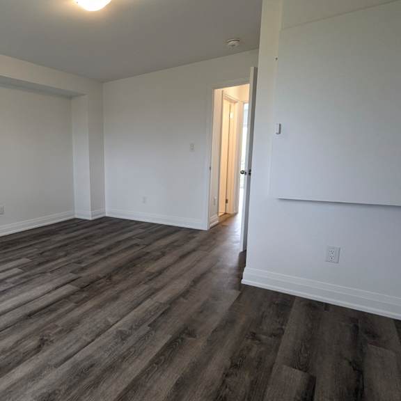 a room with wooden flooring and white walls.