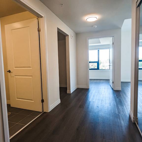 a hallway with a white door and a window.