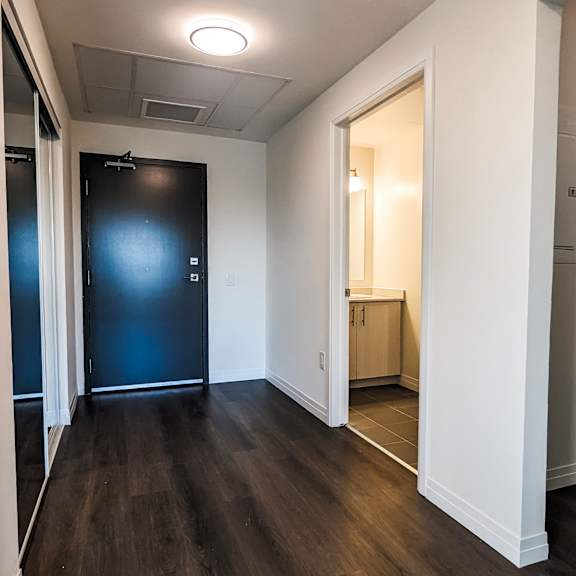 a room with a black door and wooden floors.