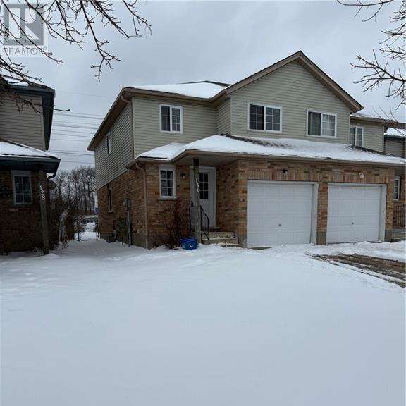 a house with a snow-covered driveway in front.