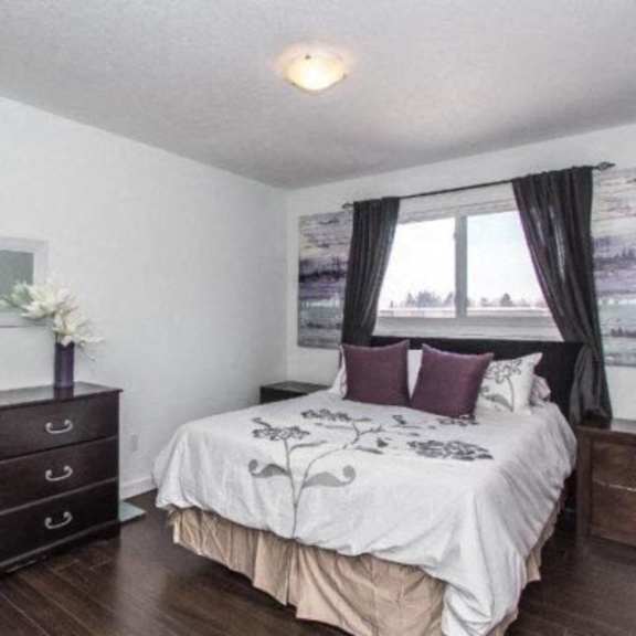 a bedroom with a bed, dresser, and nightstand.