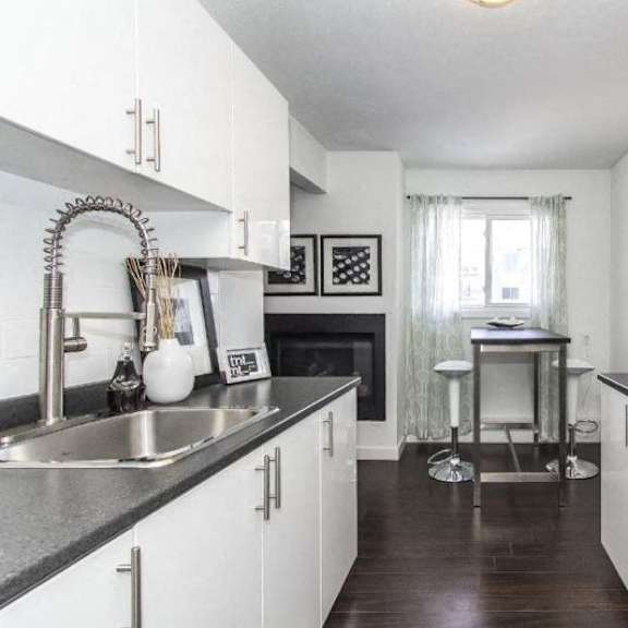 a kitchen with white cabinets and a black countertop.