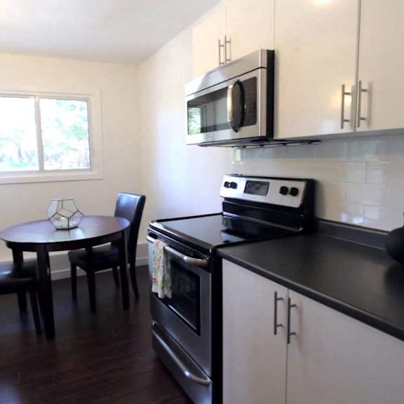 a kitchen with black and white cabinets and a stove top oven.