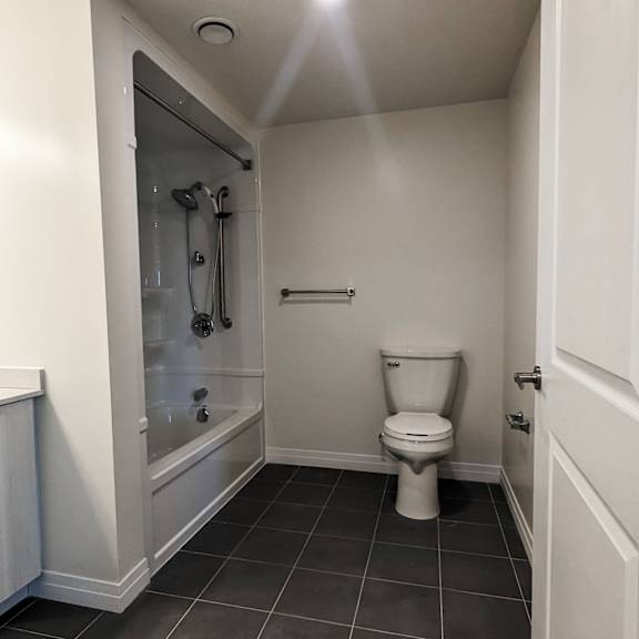 a white toilet in a small bathroom with a glass shower door.