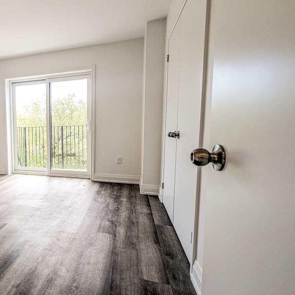 a room with a wooden floor and a white door.
