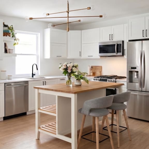 a rendering of the townhouse kitchens, with white cabinets and stainless steel appliances.