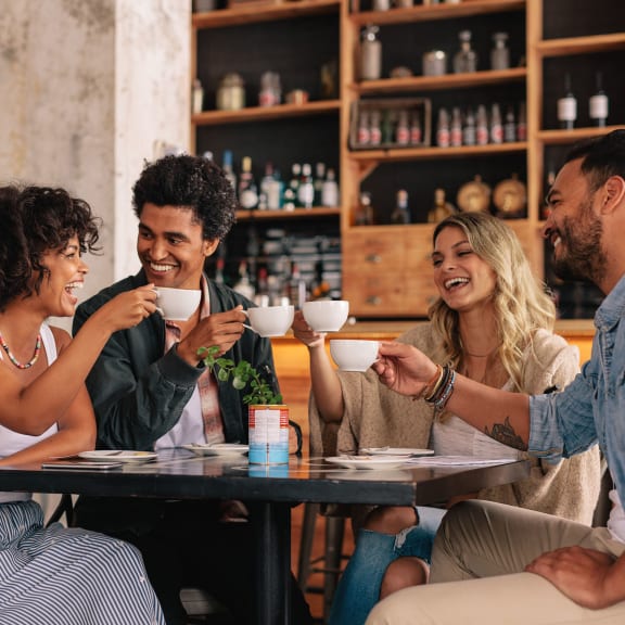 a group of people sitting at a table drinking coffee at The Indie, Boston, MA 02134
