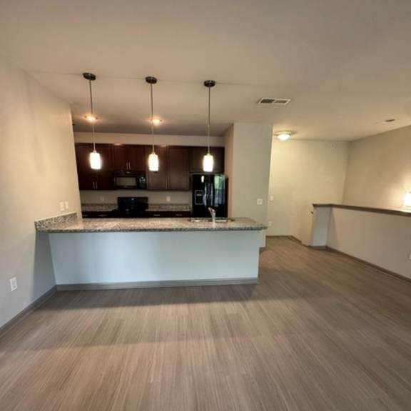 Thumbnail 2 of 2 A kitchen with a counter and cabinets is shown.