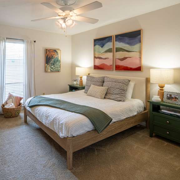 a bedroom with a large bed and a ceiling fan.