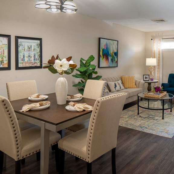 a dining room with a table set for two and a blue armchair.