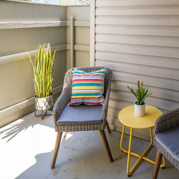 two chairs and a small table are on a patio.
