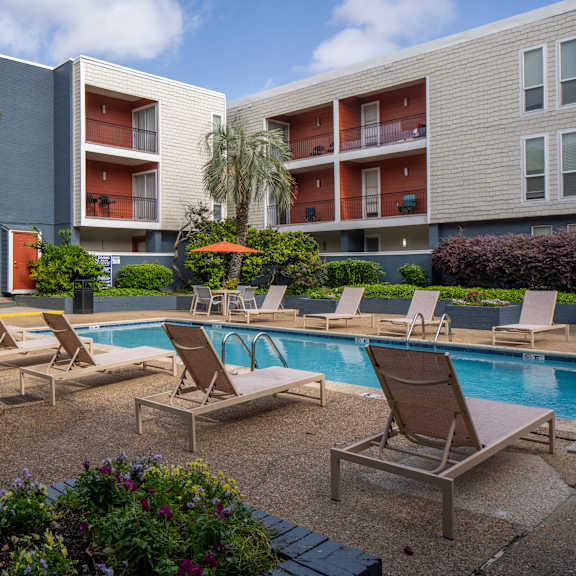a pool area with lounge chairs and a small pool.