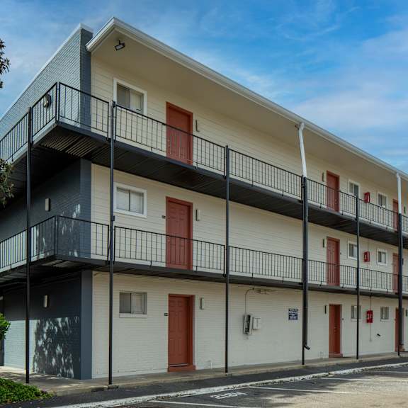 a modern apartment building with balconies and red doors.