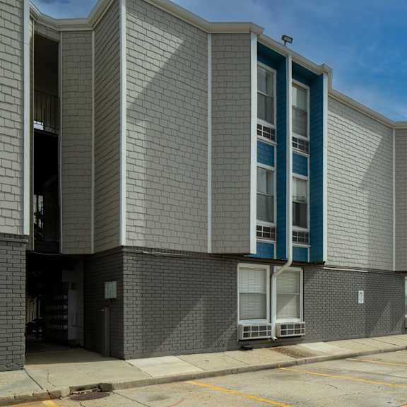 a long building with a grey facade and blue trim.