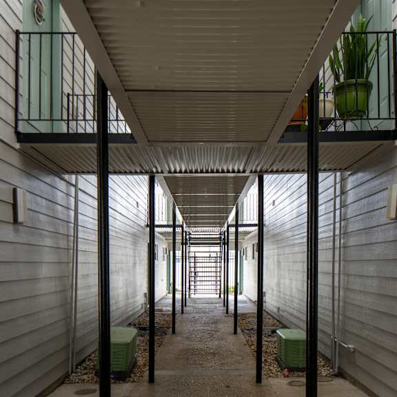 a long, narrow hallway with a balcony on the second floor.