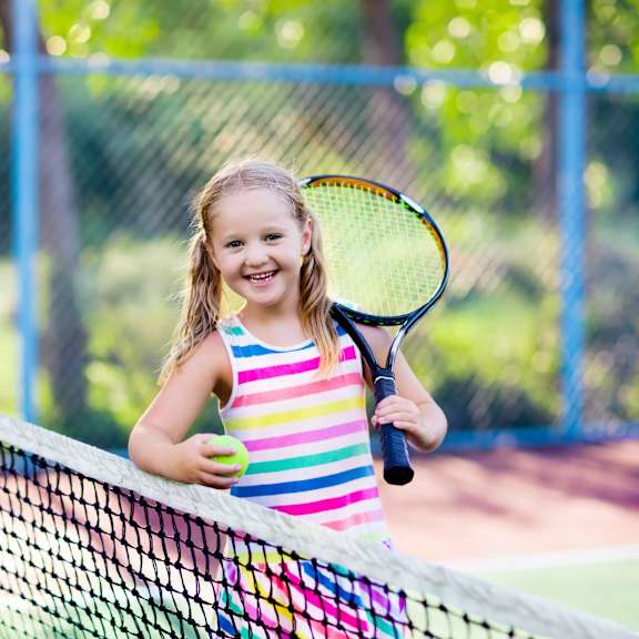 little girl playing tennis