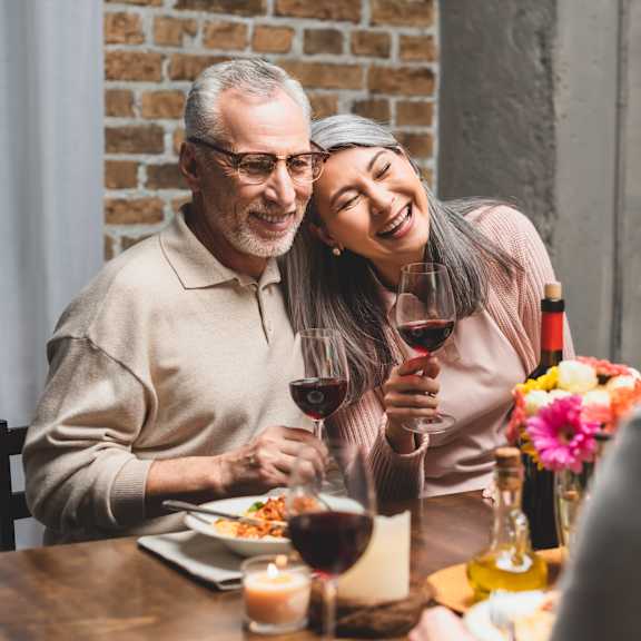 older couple laughing at dinner