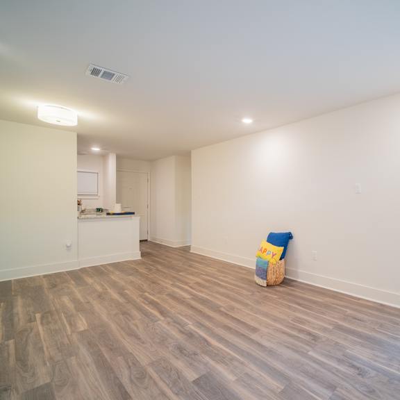 a kitchen and living room with hardwood floors and white walls