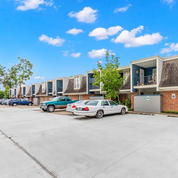 a parking lot with a building and cars parked in front.