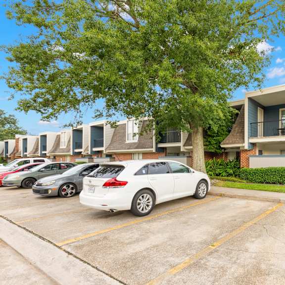 a white car is parked in a parking lot in front of a building.