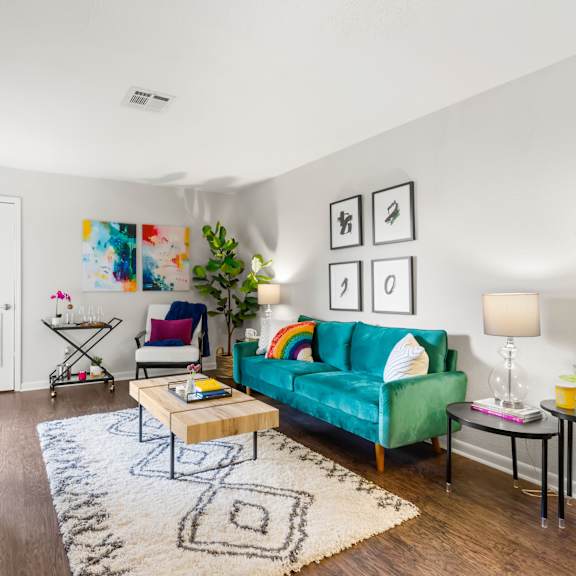 a living room with a green couch and a rug.