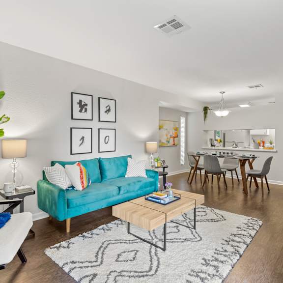 a living room with a blue couch and a rug.
