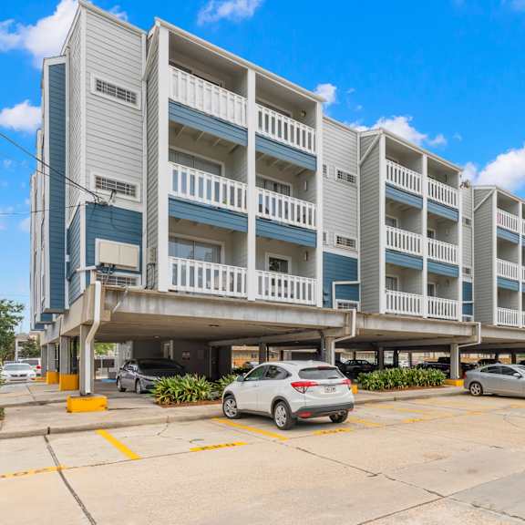 a parking lot in front of a multi-story apartment building.