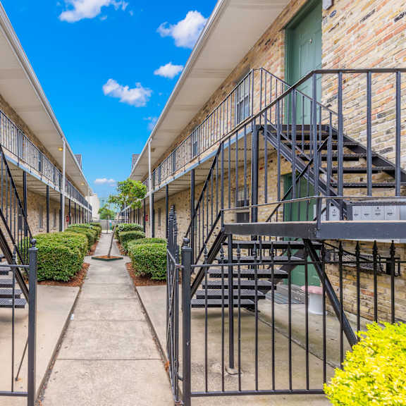 a row of buildings with metal staircases leading to the second floor.