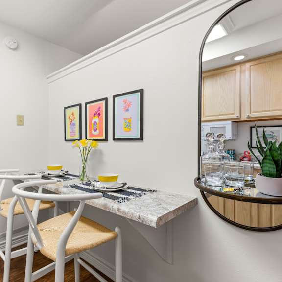 a dining area with a white table and chairs.