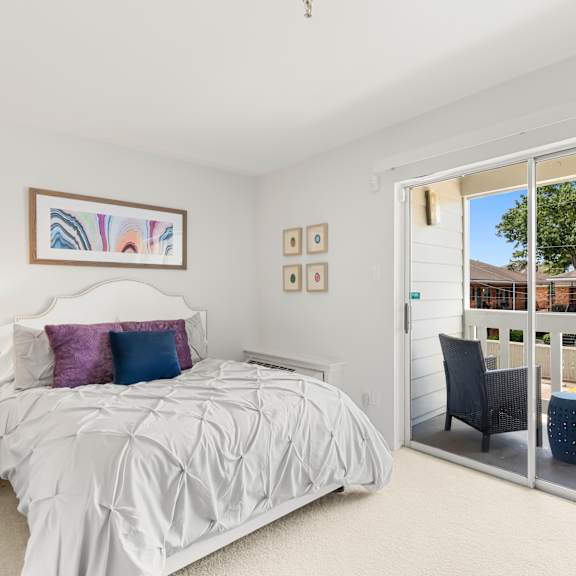a bedroom with a large bed and a balcony.
